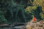 lady meditating near a river